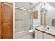 Well-lit bathroom features a shower-tub combo with glass doors and a vanity with ample counter space at 2637 Sunburst Ct, Lake Wales, FL 33898