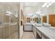 Well-lit bathroom with dual sinks, a large mirror, and a glass-enclosed shower at 2637 Sunburst Ct, Lake Wales, FL 33898