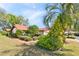 Well-maintained home with a red tile roof, surrounded by lush landscaping, mature trees, and a brick walkway at 2637 Sunburst Ct, Lake Wales, FL 33898