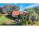 Beautifully landscaped exterior featuring a red-tiled roof, lush lawn, and mature trees at 2637 Sunburst Ct, Lake Wales, FL 33898