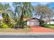 Charming home featuring mature landscaping, an attached garage, and a vibrant, red-toned driveway at 2637 Sunburst Ct, Lake Wales, FL 33898