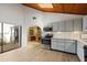 Open-concept kitchen featuring modern appliances, wooden ceiling, and ample natural light from adjacent dining area and courtyard at 2637 Sunburst Ct, Lake Wales, FL 33898