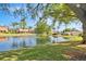 Scenic view of a serene pond with a fountain, surrounded by lush greenery and well-maintained lawns at 2637 Sunburst Ct, Lake Wales, FL 33898