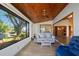 Cozy sunroom with wood ceiling, tiled floors, and large windows showcasing the outdoor scenery at 2637 Sunburst Ct, Lake Wales, FL 33898