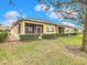 Rear view of a house with a screened porch and green backyard at 2723 Rutledge Ct, Winter Haven, FL 33884