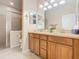 Well-lit bathroom featuring a double vanity, tile floors, and glass shower at 2723 Rutledge Ct, Winter Haven, FL 33884