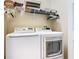 Functional laundry room with modern white washer and dryer, plus overhead storage at 2723 Rutledge Ct, Winter Haven, FL 33884