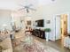 Bright living room with a ceiling fan, decorative fireplace, and an open view to the kitchen at 2723 Rutledge Ct, Winter Haven, FL 33884