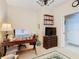 Office space with a wooden desk, shelving, TV, and a view of the doorway at 2723 Rutledge Ct, Winter Haven, FL 33884