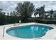 Relaxing community pool with lake view featuring lounge chairs and a secure fenced perimeter at 2723 Rutledge Ct, Winter Haven, FL 33884