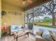 Relaxing screened porch with comfortable seating and a scenic view of the lake and lush greenery at 2723 Rutledge Ct, Winter Haven, FL 33884