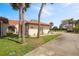 Charming front exterior of home with barrel tile roof, lush landscaping, and paved driveway at 2725 Clubhouse Dr, Lake Wales, FL 33898