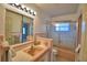 A full bathroom with a single sink vanity, a framed mirror, and a shower with patterned glass at 3065 E Central Ave, Bartow, FL 33830