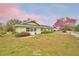 Inviting exterior with lush landscaping, blooming tree, and well-maintained lawn at 3065 E Central Ave, Bartow, FL 33830
