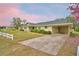 A view of the exterior showcasing a carport and a spacious driveway with lovely surrounding foliage at 3065 E Central Ave, Bartow, FL 33830