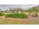 Charming front yard landscaping with mature bushes and flowering tree petals on the ground at 3065 E Central Ave, Bartow, FL 33830