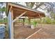 Outdoor shed with open sides, dirt floor and seating, surrounded by natural foliage at 3065 E Central Ave, Bartow, FL 33830