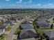 An aerial view showcases a well-situated home with manicured lawn in a vibrant community with lake views at 3686 Plymouth Dr, Winter Haven, FL 33884