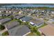 Aerial view of a home with a screened lanai in a neighborhood featuring mature landscaping and picturesque lake views at 3686 Plymouth Dr, Winter Haven, FL 33884