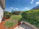 Backyard with a retaining wall, lush green grass, plants, and mulch at 3686 Plymouth Dr, Winter Haven, FL 33884