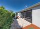 Backyard features a screened-in lanai and paver patio next to some tall hedges at 3686 Plymouth Dr, Winter Haven, FL 33884