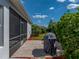 Home's backyard featuring a brick patio, well-maintained landscaping, and a covered grill at 3686 Plymouth Dr, Winter Haven, FL 33884