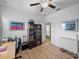 Bedroom with neutral walls, wood floors, ceiling fan, desk, and door to another room at 3686 Plymouth Dr, Winter Haven, FL 33884