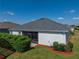 Rear exterior of home showcasing the gray shingle roof, white stucco walls, and a well-kept lawn at 3686 Plymouth Dr, Winter Haven, FL 33884