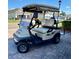 Tan colored golf cart parked in the driveway on a sunny day at 3686 Plymouth Dr, Winter Haven, FL 33884