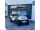 Cream colored electric golf cart parked on a paver driveway at 3686 Plymouth Dr, Winter Haven, FL 33884
