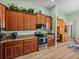 Kitchen showcases stainless steel appliances, granite counters, wood cabinets, and wood look flooring at 3686 Plymouth Dr, Winter Haven, FL 33884