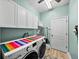 Bright laundry room featuring modern appliances, ample storage, and wood-look flooring at 3686 Plymouth Dr, Winter Haven, FL 33884