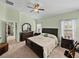 Spacious main bedroom featuring a ceiling fan, dresser, and neutral-toned carpet at 3686 Plymouth Dr, Winter Haven, FL 33884