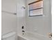 Bright bathroom features a tub with tiled walls and a window with wood blinds for natural light at 369 Villa Sorrento Cir, Haines City, FL 33844