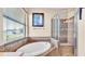 Beautiful bathroom showcasing an oval soaking tub with a tiled surround and a glass-enclosed shower at 369 Villa Sorrento Cir, Haines City, FL 33844