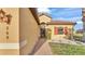 View of the home's entry way, featuring a brick pathway, stucco siding, shutters, and a well maintained lawn at 369 Villa Sorrento Cir, Haines City, FL 33844