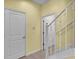 Hallway with iron railing leads to an upstairs area and a door to the left at 369 Villa Sorrento Cir, Haines City, FL 33844