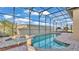 Sparkling pool and spa surrounded by brick pavers and screened enclosure at 369 Villa Sorrento Cir, Haines City, FL 33844