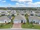 Expansive aerial view of a neighborhood showcasing well-maintained homes and landscaping, with a lake in the distance at 3711 Plymouth Dr, Winter Haven, FL 33884
