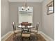 Cozy dining area with round table, four chairs, neutral paint, and natural light from the window at 3711 Plymouth Dr, Winter Haven, FL 33884