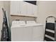 This laundry room features a modern washer and dryer, along with white cabinets for storage at 3711 Plymouth Dr, Winter Haven, FL 33884