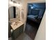 Bathroom with a green vanity and a glimpse into the cozy bedroom with calming blue tones at 4024 Canal Rd, Lake Wales, FL 33898