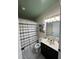 Bathroom featuring a shower with a striped curtain, dark vanity, and a mirror with decorative lighting above at 4024 Canal Rd, Lake Wales, FL 33898