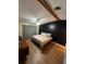 Bedroom featuring a black accent wall, ceiling fan, wood beam, wood floor, and warm colors at 4024 Canal Rd, Lake Wales, FL 33898