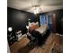 Dark bedroom features a bed, massage table, ceiling fan, and hardwood floors at 4024 Canal Rd, Lake Wales, FL 33898