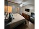 Bedroom with doorway to bathroom, tv, mirror and wood-look floors at 4024 Canal Rd, Lake Wales, FL 33898
