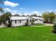 Attractive single-Gathering home with green lawn, white painted brick, a modern metal roof, and attached garage at 4024 Canal Rd, Lake Wales, FL 33898