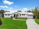 Charming single-story home featuring a bright, white brick exterior, manicured lawn, and a concrete driveway at 4024 Canal Rd, Lake Wales, FL 33898