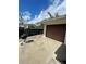 Exterior shot of garage with a barbecue pit and a concrete driveway under a partly cloudy sky at 4024 Canal Rd, Lake Wales, FL 33898