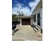Exterior of garage with a grill, a concrete pad, and steps leading up to the white siding on the house at 4024 Canal Rd, Lake Wales, FL 33898